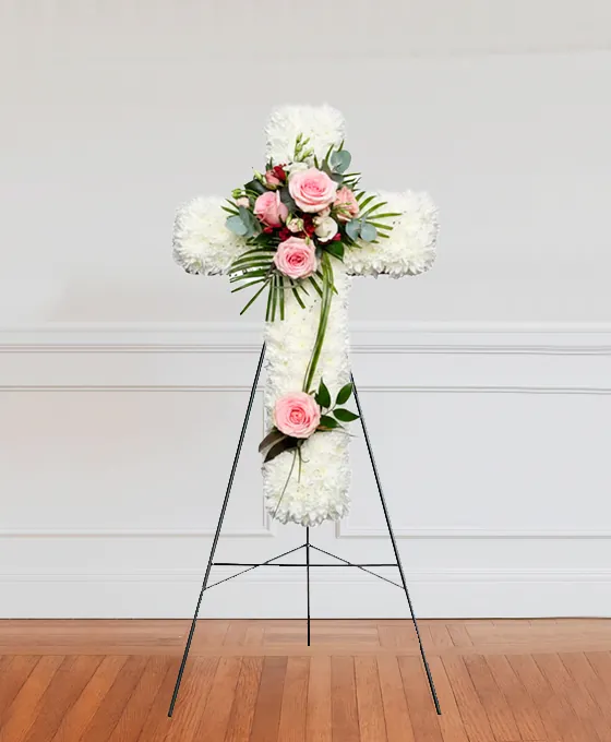 White floral cross tribute on a stand