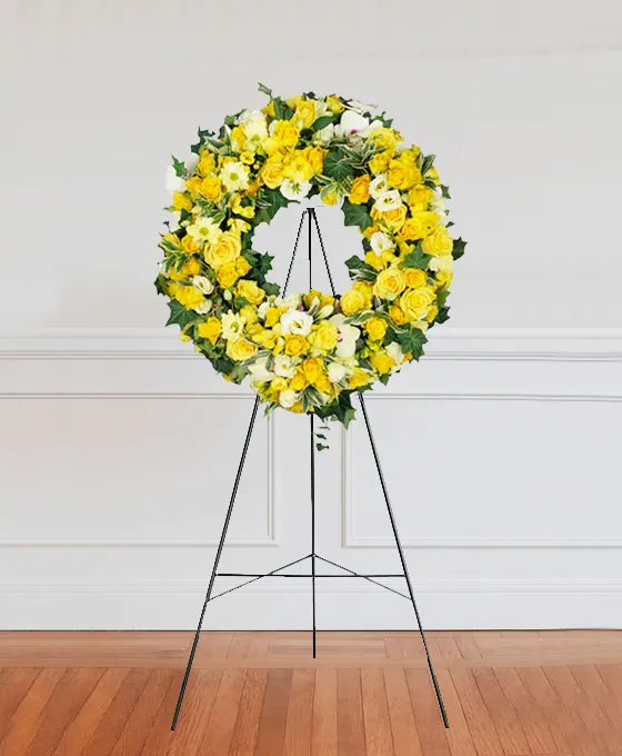 Yellow and orange funeral wreath on a stand